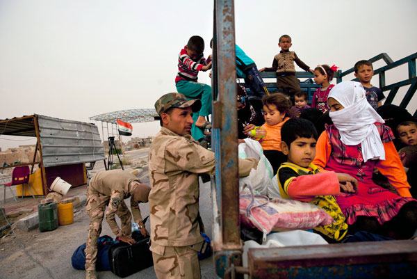 In this Sunday  photo, Iraqi soldiers search a convoy of families fleeing Deash-held Hit, Iraq, at a checkpoint on the western edge of Ramadi, Iraq (AP photo)