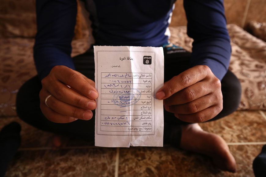 Salim Ahmed, a former Iraqi army member, holds the ‘repentance card’ he received from Daesh in June 2014 shortly after the militants took over his home village of Eski Mosul in northern Iraq, May 27 (AP photo)