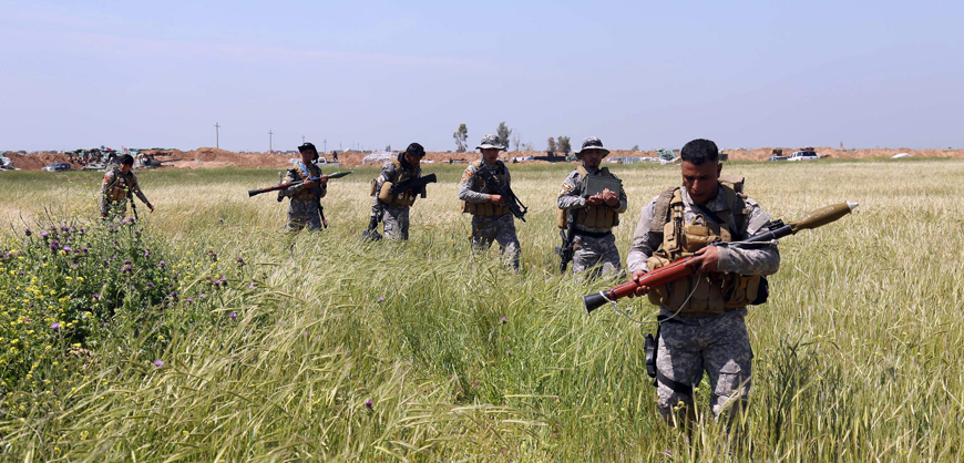Iraqi Shiite fighters from the Popular Mobilisation Unit advance during clashes in the village of Al Bashir, still controlled by the Daesh terror group, on Tuesday (AFP photo)