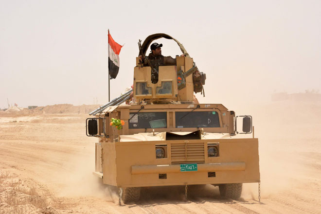 Iraqi government forces drive their armoured vehicle on Wednesday, some 40 kilometres west of Qayyarah, during their operation to take the city and make it a launchpad for Mosul (AFP photo)