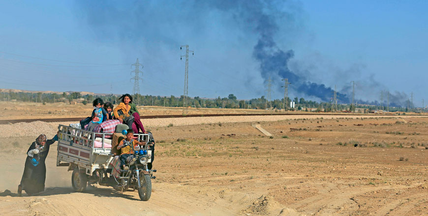 In this April 4, 2016 file photo, smoke rises as people flee their homes during clashes between Iraqi security forces and members of the Daesh militants in Hit, Iraq, 140 kilometres west of Baghdad (AP photo)