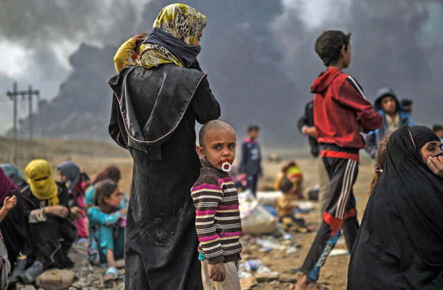 Iraqi families, who were displaced by the ongoing operation by Iraqi forces against Daesh militants to retake the city of Mosul, are seen gathering in an area near Qayyarah on Monday (AFP photo)