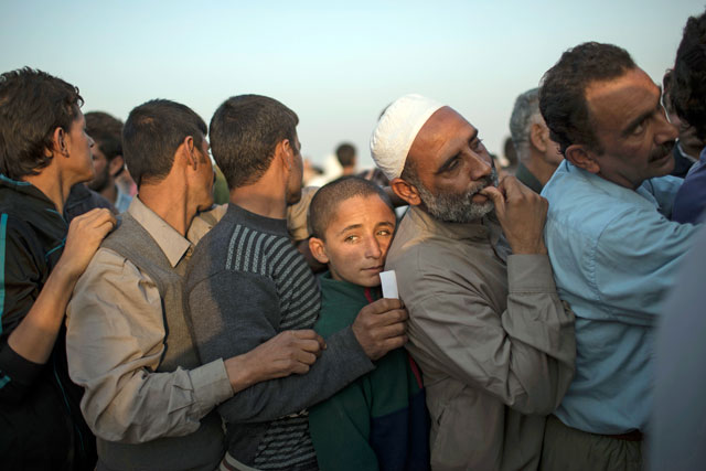 Iraqis displaced by fighting in Mosul line up for food distribution at a camp for internally displaced people in Hassan Sham, Iraq, on Tuesday (AP photo)