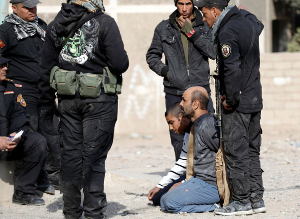 Members of an Iraqi special forces intelligence team talk to suspected Daesh militants in Mosul, Iraq, on Sunday (Reuters photo)