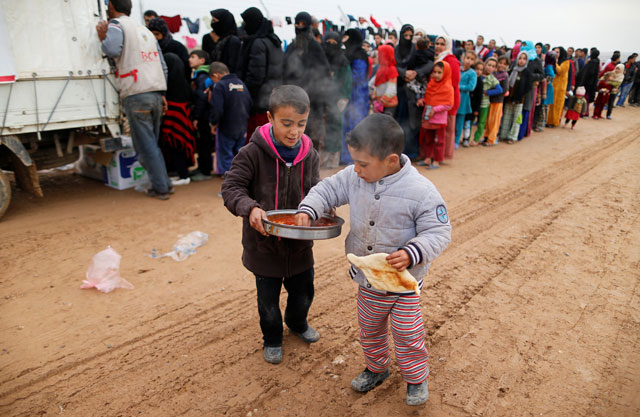 Boys, who fled the Daesh stronghold of Mosul, receive food at a refugee camp, Iraq, on Sunday (Reuters photo)