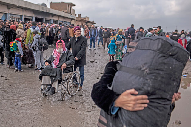 A man in a wheelchair waits to be transferred to a camp for internally displaced people, in Bartella, around 30km, from Mosul, Iraq, Monday (AP photo)