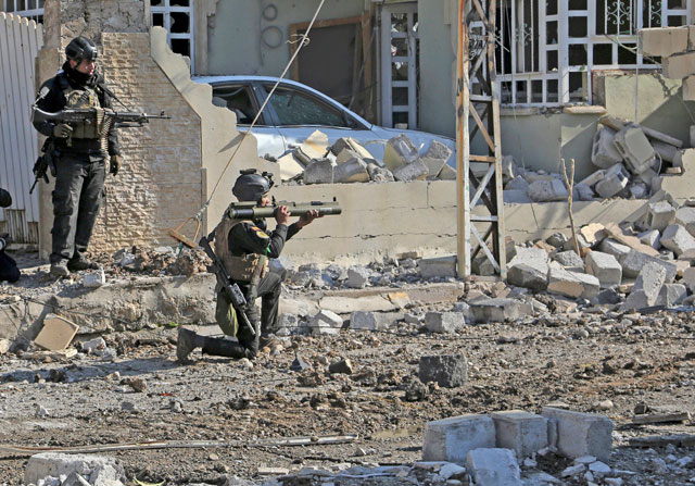Soldiers of Iraq’s special forces take combat position as they advance in the eastern side of Mosul, Iraq, Monday (AP photo)