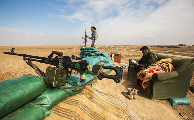 Fighters of the Hashed Al Shaabi (Popular Mobilisation) paramilitaries stand guard by defensive positions near the frontline village of Shar’iah, on the outskirts of Tal Afar west of Mosul, on Friday (AFP photo)