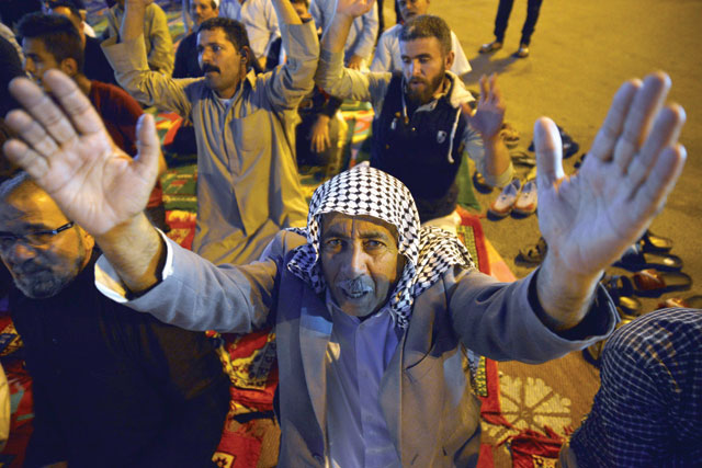 An Iraqi protester takes part in collective prayers during ongoing anti-government demonstrations in the central Shiite holy shrine city of Najaf on Sunday (AFP photo)