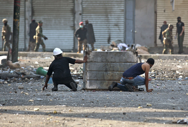 Iraqi protesters clash with Iraqi security forces at Baghdad's Khallani Square during ongoing anti-government demonstrations on Monday (AFP photo)