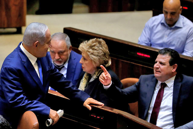 Israeli Prime Minister Benjamin Netanyahu chats with Ayman Odeh, head of the Arab Joint List, in the plenum at the Knesset, in Jerusalem, on December 26, 2018 (Reuters photo)