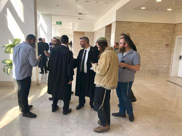 Relatives, friends and Israeli lawyers representing a 16-year-old Jewish seminary student from the occupied West Bank charged with killing a Palestinian woman Aisha Al Rawbi in 2018, stand outside the courtroom at the district court in Lod, Israel, on Thursday (Reuters photo)