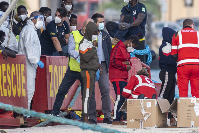 Volunteers from the Italian Red Cross (right) welcome migrants rescued in the Mediterranean Sea as they disembark from the Sea-Eye 4 ship on Sunday in the port of Trapani, Sicily (AFP photo)