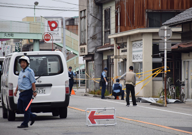 Policemen conduct investigations in front of a police station where a colleague was stabbed in central Toyama prefecture on Tuesday   (AFP photo)