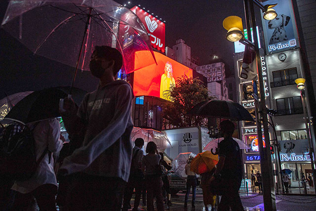 People walk on a street in Tokyo's Shinjuku district as Japan announces a new virus state of emergency stretching throughout the Tokyo Olympics, on Thursday (AFP photo)