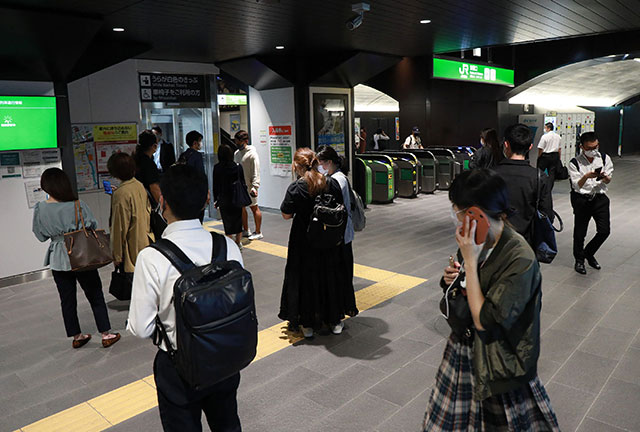 Passengers wait at a station as train services are suspended in Tokyo on Thursday after a 6.1-magnitude earthquake shook the Japanese capital and surrounding areas (AFP photo)