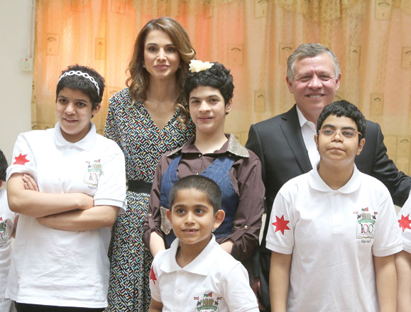 Their Majesties King Abdullah and Queen Rania with children served by a charity centre in Ruseifa on Sunday  (Photo courtesy of Royal Court)
