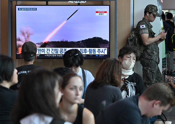 A South Koran soldier (right) stands next to a television screen showing a news broadcast with file footage of a North Korean missile test, at a railway station in Seoul, on Saturday (AFP photo)