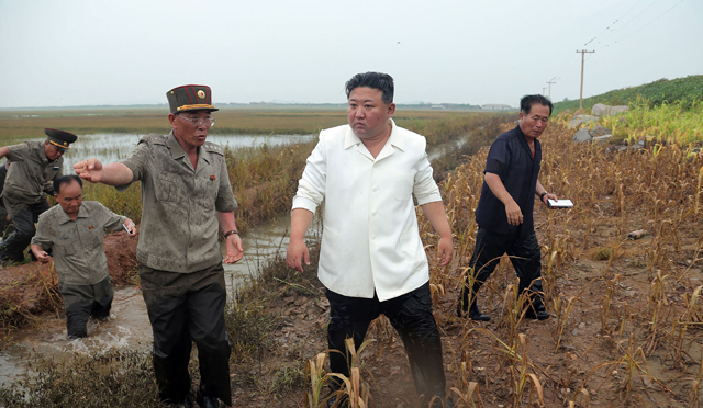 This photo taken on Monday and released from North Korea’s official Korean Central News Agency (KCNA) on Tuesday shows North Korea’s leader Kim Jong-un (centre) visiting the restoration site of reclaimed land which suffered flood damage due to the levee breaking in the western port city of Nampo (AFP photo)