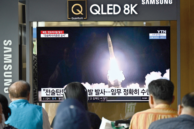 People watch a television showing a news broadcast with a photo of a North Korean missile test, at a railway station in Seoul, on Thursday (AFP photo)