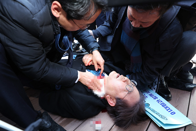 South Korean opposition party leader Lee Jae-myung is attended to after being attacked in Busan on Tuesday (AFP photo)