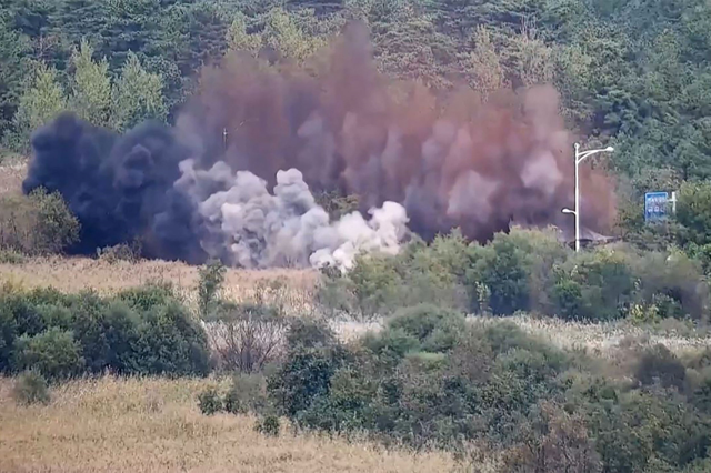 his screen grab taken from video released by the South Korean Defence Ministry and filmed from an undisclosed location in South Korea along the inter-Korean border shows an explosion on a road connecting North and South Korea on Tuesday (AFP photo)