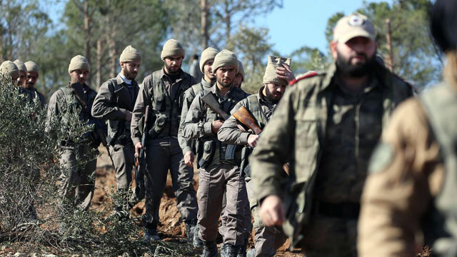 Turkish-backed Syrian rebels march on Mount Barsaya north of Azaz, on January 29, 2018, as the Turkish offensive against Kurdish forces in the Syrian border region of Afrin continues (AFP photo)