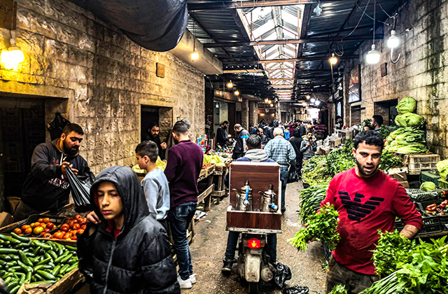 People shop for fruits and vegetables at a market in the Lebanese port city of Tripoli amid the outbreak of COVID19 on March 30, 2020 (AFP photo)