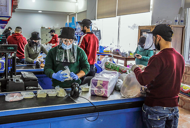 Employees work while wearing  protective face shields and gloves at the northern city of Batroun on March 23, Monday (AFP photo)