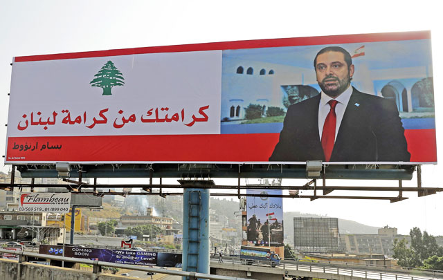 A poster of Lebanese prime minister, Saad Hariri, is seen on a giant billboard that reads in Arabic ‘Your dignity is Lebanon’s dignity’ on the highway of Zouk Mosbeh, north of Beirut, on Tuesday (AFP photo)