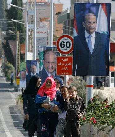 People walk past posters of Christian leader Michel Aoun in the southern port city of Sidon, Lebanon, on Sunday (AP photo by Mohammed Zaatari)