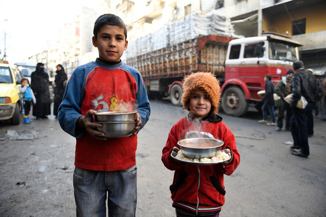 Children carry cooked meals provided by the UN through a partner NGO at Al Mashatiyeh neighbourhood of East Aleppo, Syria, in this handout photo provided by UNHCR on Wednesday (Reuters photo)