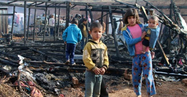 Syrian refugees check the damage following a fire that ripped through their refugee camp in the village of Yammouneh  in Lebanon’s eastern Bekaa Valley, on Monday (AFP photo)
