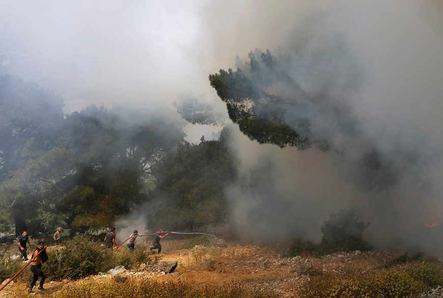 Volunteers help to extinguish a forest fire in the Qubayyat area of northern Lebanon’s remote Akkar region on Friday (AFP photo)