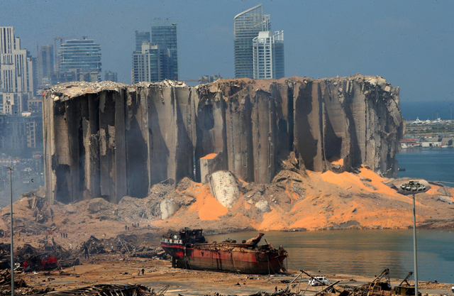 This file photo taken on August 5, 2020, shows the damaged grain silos and a burnt boat at Beirut’s harbour, a day after a powerful twin explosion tore through Lebanon’s capital, resulting from the ignition of a huge depot of ammonium nitrate at the city’s main port (AFP photo)