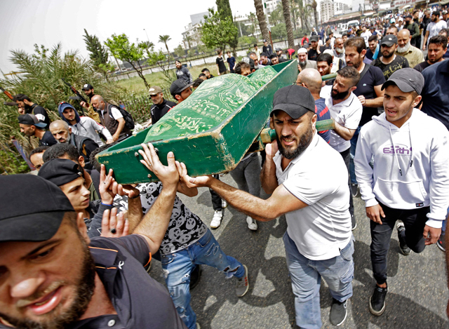 Mourners carry a body, killed after a boat loaded with migrants capsized near the coast of the northern city of Tripoli, during a funeral in the northern Lebanese city, on Monday (AFP photo)