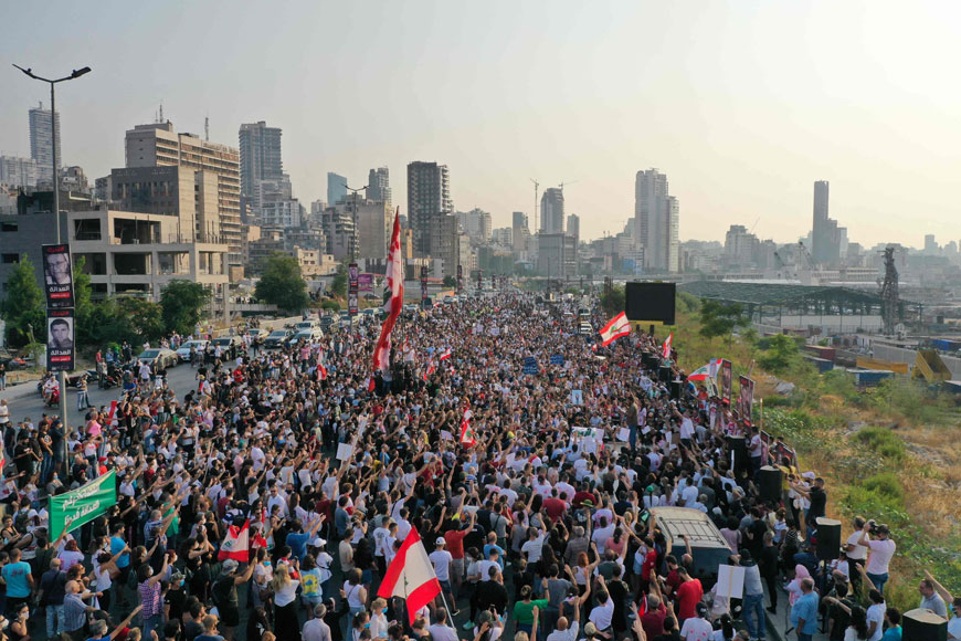 This aerial view shows activists and relatives of the 2020 Beirut port blast victims raising national flags, as they march in the Lebanese capital's port area on Thursday, on the day that crisis-hit country marks two years since a giant explosion ripped through the capital (AFP photo)