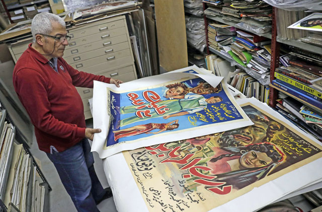 Abboudi Abu Jawdeh shows part of his vintage cinema poster collection at his office in the Lebanese capital Beirut, on April 23 (AFP photo)