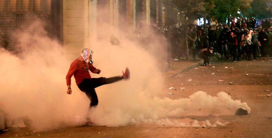 A Lebanese demonstrator kicks back a tear-gas canister during clashes with riot police in the capital Beirut on Sunday (AFP photo)