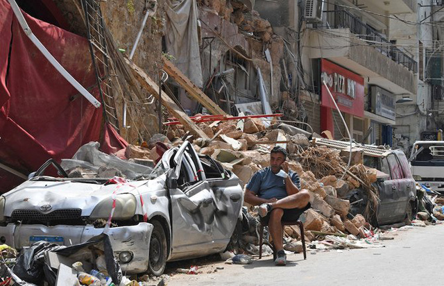 A man talks on the phone while seated in rubble of a destroyed building in Gemmayzayeh neighbourhood after the explosion that devastated Beirut (AFP photo)