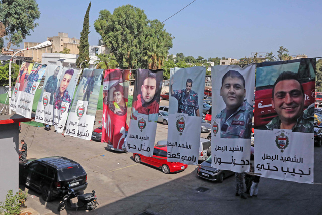 Photos of Lebanese firefighters who died in the line of duty are hung along a street in the Lebanese capital Beirut, on September 28 (AFP photo)