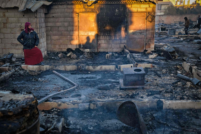 Syrian refugees salvage belongings from the wreckage of their shelters at a camp set on fire overnight in the northern Lebanese town of Bhanine on Sunday (AFP photo)