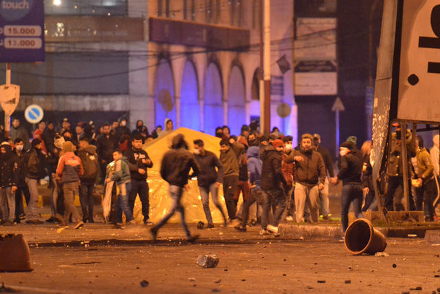Lebanese anti-government protesters clash with security forces following a demonstration against dire economic conditions, in the northern city of Tripoli, on Monday (AFP photo)