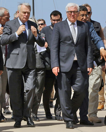 French Foreign Minister Jean-Marc Ayrault (left) and German Foreign Minister Frank-Walter Steinmeier walk on the tarmac upon their arrival in the Libyan capital, Tripoli, on Saturday (AFP photo)