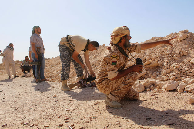 Fighters from forces aligned with Libya’s new unity government are seen stationed behind the barricade as they advance on Sirte on Friday (Reuters photo)