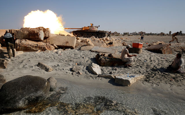 A fighter of Libyan forces allied with the UN-backed government fires a shell with Soviet made T-55 tank at Daesh militants from a beach in Sirte, Libya, on Wednesday (Reuters photo)