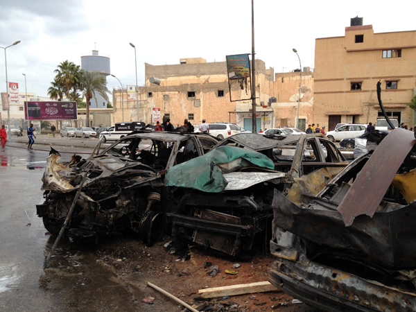People look at the remnants of a car at the scene of a car bomb in Benghazi, Libya, on Monday (Reuters photo)