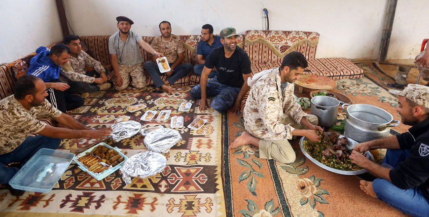 Fighters loyal to the Libyan internationally-recognised Government of National Accord prepare the Iftar meal for fellow fighters before breaking their fast at the front lines in the suburb of Al Swani, 25 kilometres south of Tripoli, on Friday (AFP photo)