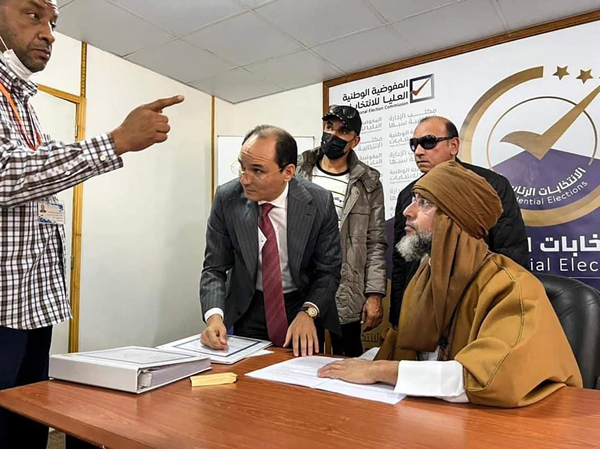 A handout photo released by the Libyan High National Commission Facebook Page on Sunday, shows Seif Al Islam Qadhafi (left),  registering to run in the country's December presidential polls, in Libya's southern city of Sebha (AFP photo)