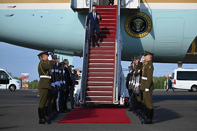 US President Joe Biden is greeted by a military honour guard as he disembarks from Air Force One, upon his arrial at Vilnius International Airport in Lithuania on Monday for the NATO summit (AFP photo)